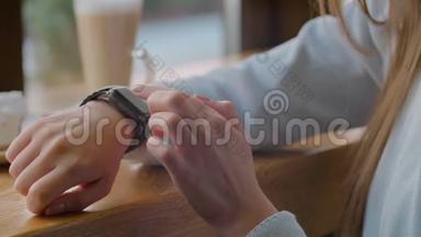 女士使用智能手表触摸屏可穿戴技术设备。 特写镜头。 在智能手表上做手势的漂亮女孩