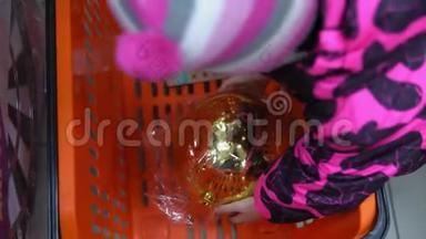 这孩子在超市的购物篮里放了一个圣诞树球。