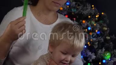 快乐的妈妈在花环上梳理着圣诞树的背景，绿色的<strong>UFO</strong>火球，发光的球体，闪烁着
