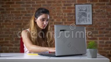 一位了不起的白种女商人正在开发笔记本电脑，然后展示了她举起双臂的<strong>致胜</strong>姿势