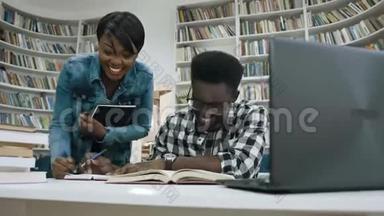 非洲女孩和男孩在学生图书馆准备考试时聊天和<strong>大笑</strong>。
