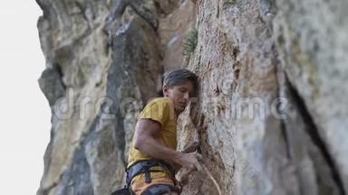 年轻的<strong>攀岩</strong>者开始在悬崖上<strong>攀岩</strong>，寻找，伸手抓住。