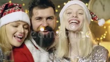 靠近一个长胡子的男人和两个金发女孩燃烧孟加拉灯。 新年派对。 新年的心情。 圣诞节