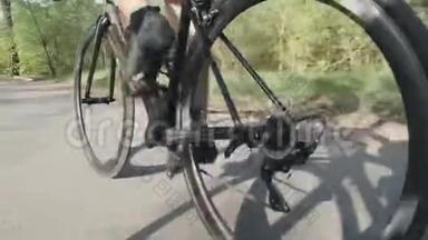 骑自行车的骑自行车的人腿部肌肉强壮。 在自行车上跟随骑自行车的腿的镜头。