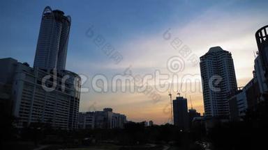 日落时摩天大楼和建筑起重机的剪影。 城市建筑上美丽的天空背景，城市