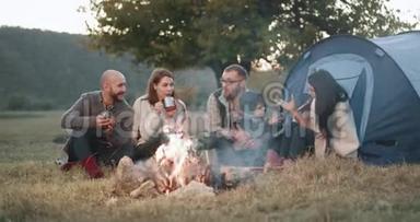 篝火时间，一群朋友，在野餐时<strong>搭帐篷</strong>，一个年轻的家庭和他们的孩子一起玩耍