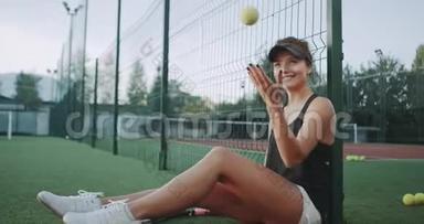 微笑着美丽的运动女人，在网球比赛前在摄影师面前玩网球。