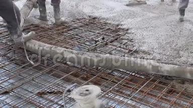 工人们<strong>正在施工</strong>现场的大钢筋地板上摊铺混凝土