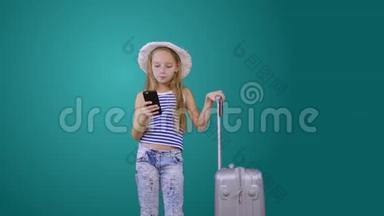 带<strong>旅行箱</strong>和手机的旅游女孩被隔离在绿色背景下
