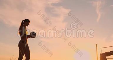 一位身穿比基尼、日落时带球的美女正准备在沙滩<strong>排球比赛</strong>中发球跳跃