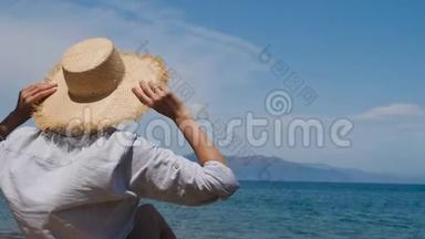 穿着衬衫戴着<strong>帽子</strong>的女孩坐在沙滩上的<strong>遮阳</strong>伞下