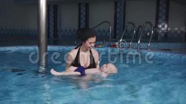 一位年轻的母亲教她的小儿子在<strong>游泳</strong>池里<strong>游泳</strong>。 <strong>游泳</strong>训练。