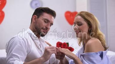 男人把珍贵的订婚戒指戴在幸福的女士手指上，提出求婚