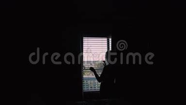 快乐的少女在酒店的公寓`床上放松。 女孩锁在窗户上。 暑假心情