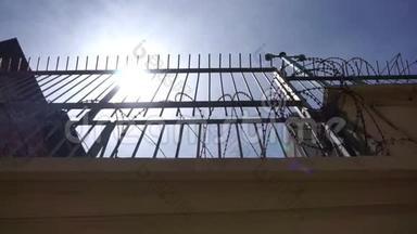 很高的监狱围栏，有铁栅栏和尖锐的带刺铁丝网
