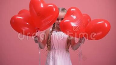 可爱的小女孩躲在心形气球后面情人节惊喜