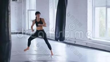 跆拳道职业运动员女子在健身房踢拳袋。 体育跆拳道女子在健身房训练。