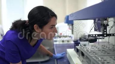 描绘年轻的实验室妇女穿着蓝色制服和橡胶手套控制实验室的药物制造。 <strong>开展</strong>活动