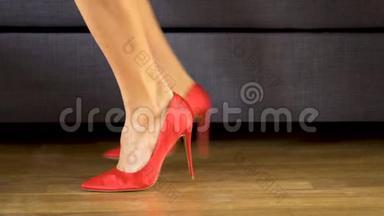 女人穿着红色的高跟鞋走着，双腿交叠