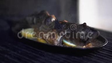 躺在柠檬片上的鲭鱼冒着热气. 现代餐厅的美味海鲜准备。 带烤的开胃菜