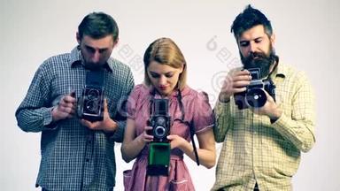 古董相机的概念。 摄影师`工作室。 三位年轻摄影师。