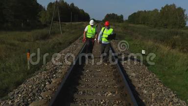 铁路工程师与助理人员一起检查铁路钢轨
