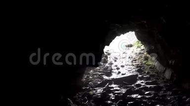 黑暗洞穴出口明亮的阳光，神秘的自然。 库存录像。 库存录像。 从里面看