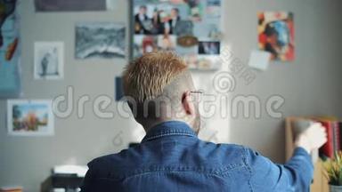 在家中可以看到英俊的男学生黄色的头发和时尚的发型。 看书。 使用教科书。