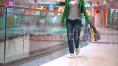 带着购物袋在商场里散步的女人。 概念：时尚，销售，购物，幸福.. 双腿合拢。 最后报告