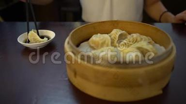4K亚洲女人在餐馆吃饺子。 传统的中国菜