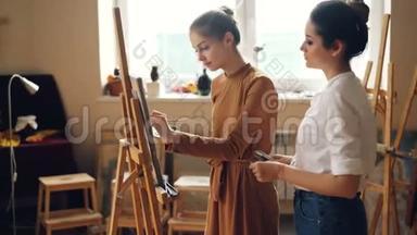 艺术学院专业教师正与勤奋的女学生合作，进行绘画和谈话分享经验