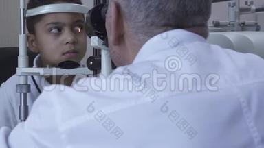 小帅哥在诊所做眼科检查坐在医生面前穿着白色的医用外套看着验眼机