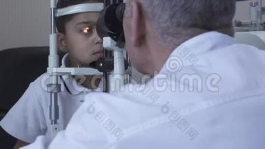 小帅哥在诊所做眼科检查坐在医生面前穿着白色的医用外套看着验眼机