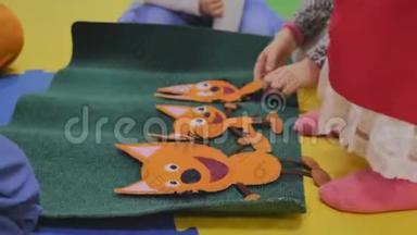 动画师和孩子们一起在孩子们的房间里玩`毛绒贴纸贴上图片，只有手是可见的，特写的