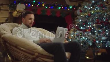 成年男子在圣诞夜使用笔记本电脑在社交网络上发短信