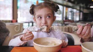 饥饿的女孩在餐馆吃饺子。