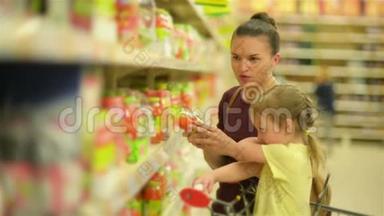 妈妈和女儿正在超市买果汁。 超市购物更有趣。