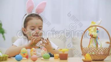 可爱的小女孩真诚地微笑着。 她拿了一个复活节彩蛋，用她的方式展示了她的工作成果