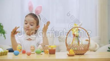 可爱的小女孩真诚地微笑着。 她拿了一个复活节彩蛋，用她的方式展示了她的工作成果
