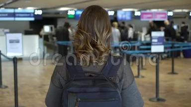 旅行者女在出发前站在机场。 在机场背包的女孩