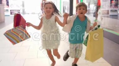 快乐的孩子们带着购物袋，在黑色星期五的促销活动中以折扣的方式跑去购物
