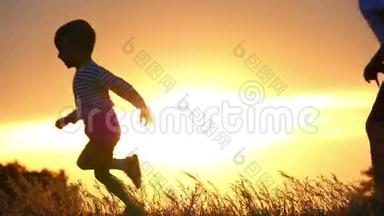 两个快乐男孩在夕阳背景下奔跑的慢动作<strong>剪影</strong>