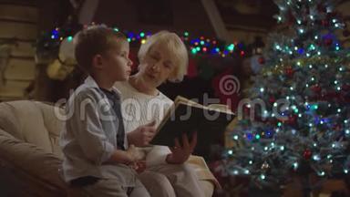 孙子坐在她身边，在圣诞夜和他说话，祖父在为他读一本书