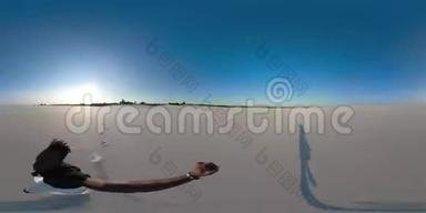 360虚拟现实。 快乐的非洲男人手里拿着360相机穿过沙漠