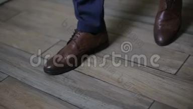 穿着裤子和棕色皮鞋的人在室内行走。 跟踪拍摄的人`皮鞋，特写。