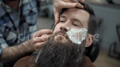 理发师在<strong>理发店</strong>或<strong>理发店</strong>用直刃剃须刀刮胡子。 男人`理发和刮胡子