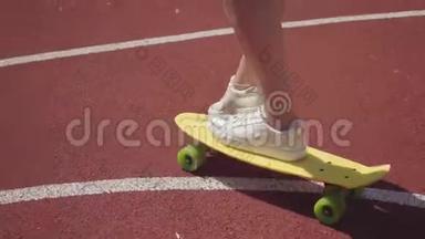 特写女腿穿白色运动鞋女孩骑黄色滑板在户外篮球场.. 体育概念