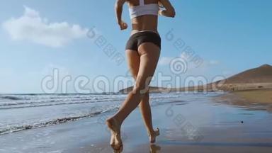 健身跑步女子在海滩上跑步，听音乐动机与手机壳运动臂带。 运动运动员