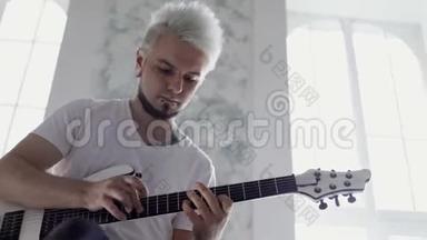 在客厅里弹吉他的人