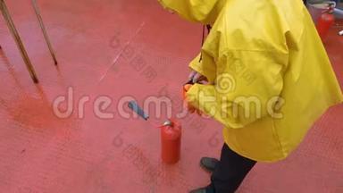 消防队员穿黄色雨衣将灭火器烤架内的火扑灭..